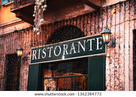 Restaurant sign on old house. Led string lights on the wall.