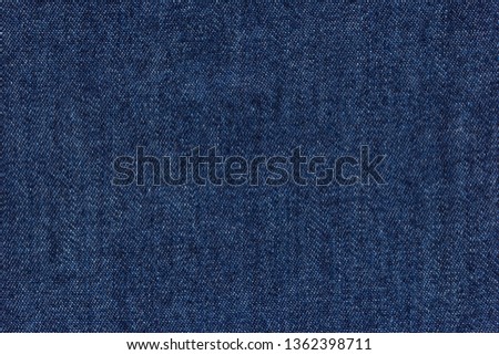 Old blue denim jeans texture or background with visible fibers
