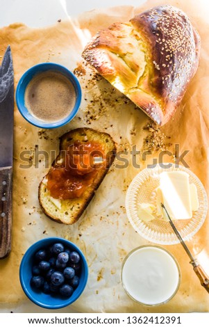 Sliced Challal bread with white and black sesame seeds covered with homemade jam, greek yogurt and   blackberry for challal is the typical jewish bread eaten by family for the saturday celebration, to