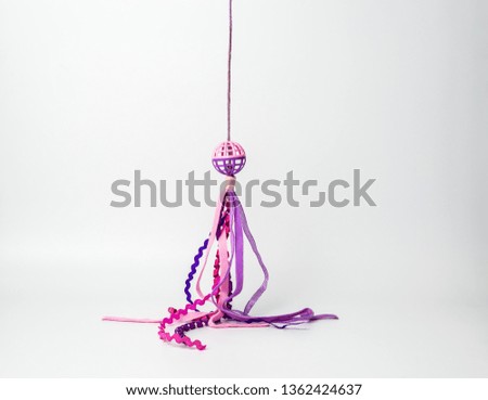 Cat Toy with a purple and pink band on white background  with copy space 