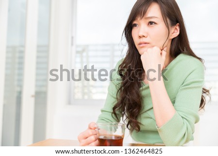 young attractive asian woman who drink tea,thinks