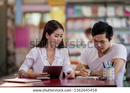 Young students learning,library bookshelves on background