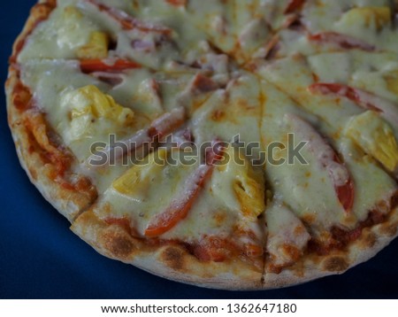 Hawaiian Pizza with Pineapple, Ham Slice, Bacon Slice, Mozzarella Cheese, Pizza Sauce on table