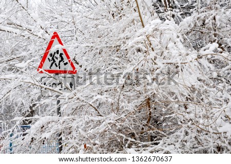 Russian road sign "Children" on a background of snow-covered bus