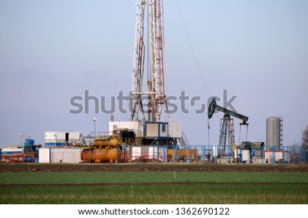 land oil drilling rig and pump jack in oilfield 