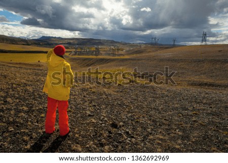 Happy tourist woman in bright clothes and yellow coat , enjoying traveling Iceland