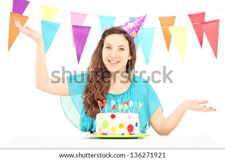 A smiling birthday female with a party hat posing isolated against white background