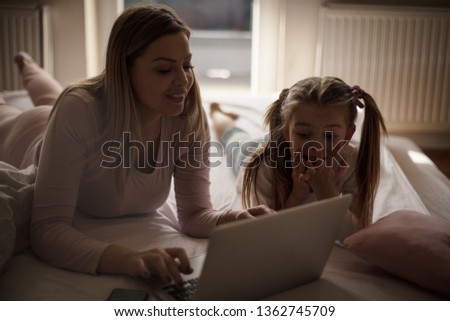 Mom what are you doing? Mother daughter using laptop.