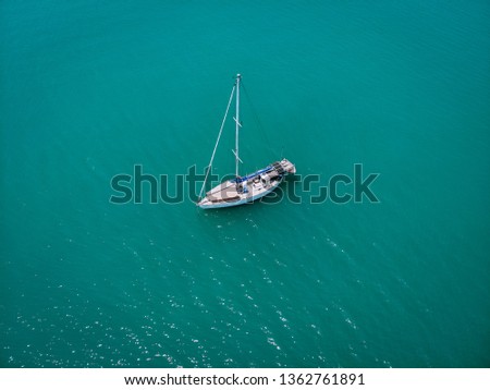 Aerial view of a single sailing yacht in the turquoise water of the Andaman sea. Phuket. Thailand