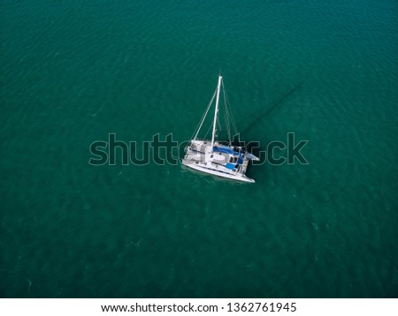 Aerial view of a single sailing yacht in the turquoise water of the Andaman sea. Phuket. Thailand