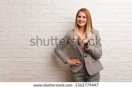 Young russian business woman smiling and pointing to the side