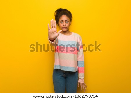 Young black african american girl with blue eyes putting hand in front