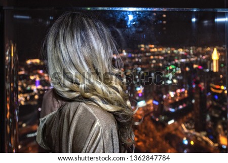 Woman on rooftop Dubai, United Arab Emirates. Cityscape view at night