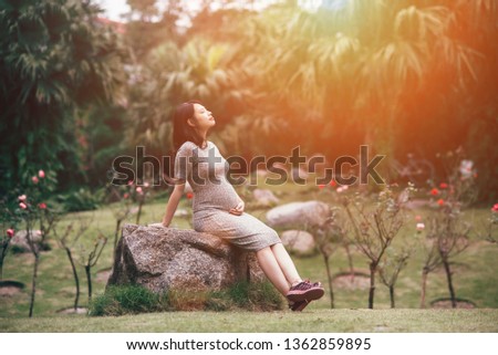 A asian pregnant is happy with her body, her foetus. Royalty-Free Stock Photo #1362859895