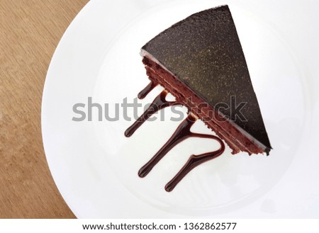 Top view , close up picture of chocolate cake with chocolate sauce art on white dish.