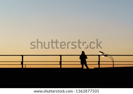Human silhouette at sunset on the observation deck in the city