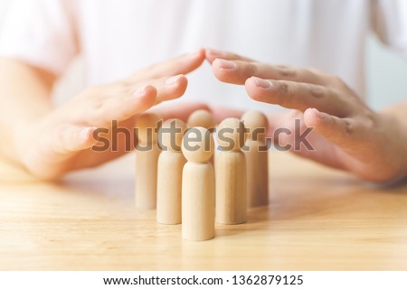 Protection people health and insurance concept. Hand shield protect wooden human on table