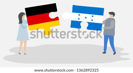 Couple holding two puzzles pieces with German and Honduran flags. Germany and Honduras national symbols together.