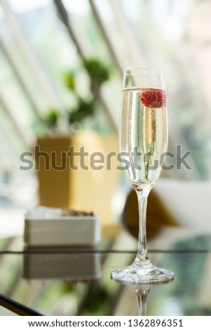 Prosecco with raspberry.  Champagne glass at hotel lobby bar.