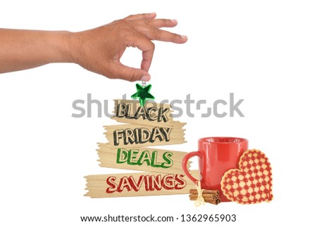 Black Friday Deals Savings Wood Tree Shape Sign Green Star hanging next to red mug heart shaped cookie and cinnamon sticks from hand white background