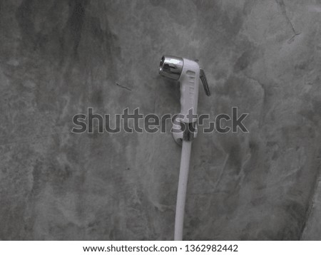 White sprinkler with concrete walls, gray bathroom.