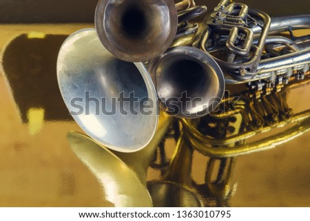 Brass instruments reflected on a golden surface