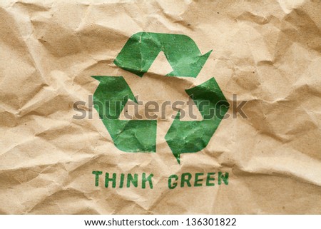 Green recycle symbol on crumpled cardboard