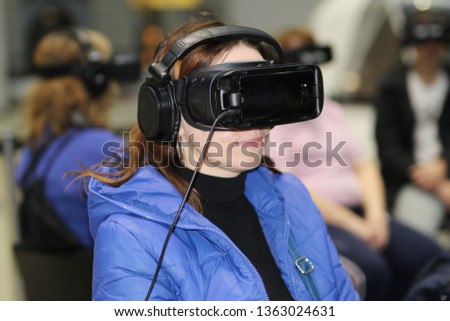 Virtual reality glasses with headphones. Goggles-helmet additional reality worn on the person. The man is in three-dimensional virtual reality.