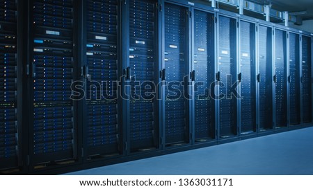 Shot of Modern Data Center With Multiple Rows of Fully Operational Server Racks. Modern High-Tech Telecommunications Database Super Computer in a Room. Royalty-Free Stock Photo #1363031171