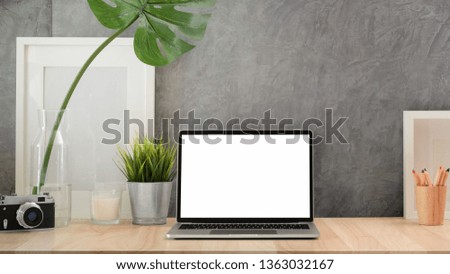 Blank screen laptop on loft workspace desk	