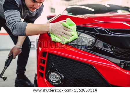 A man cleaning car with cloth, car detailing (or valeting) concept. Selective focus.  Royalty-Free Stock Photo #1363059314