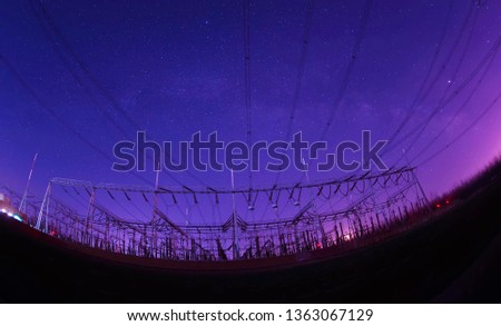 At night, the high voltage tower and substation, in a beautiful starry sky background