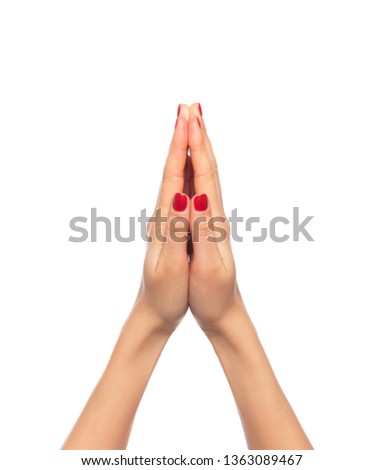 Women's hands are folded together for prayer on a white background.