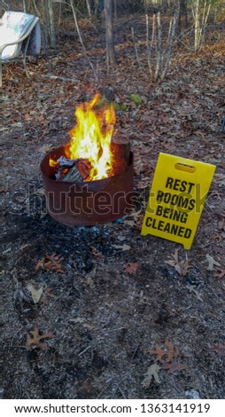 fire pit with sign next to it saying restrooms being cleaned