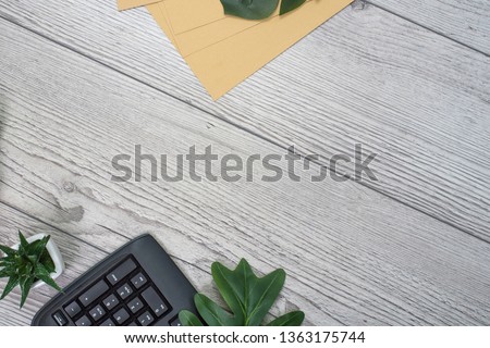 Flat lay, top view office table desk. Workspace with blank clip board, keyboard, office supplies, smartphone and alarm clock on wooden background. office products and stationery framed.