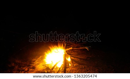 burning Sparks of a campfire in the night. Top of a mountain along with the darkness. Camping life with flames of fire.
