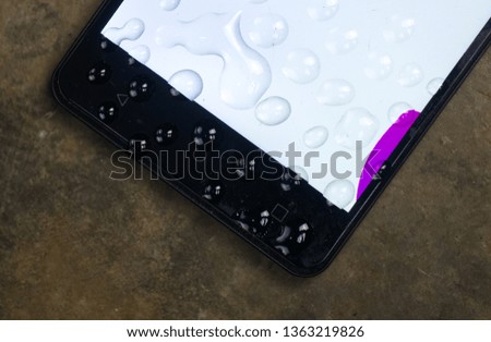                                mobile phone wet with wáter drops