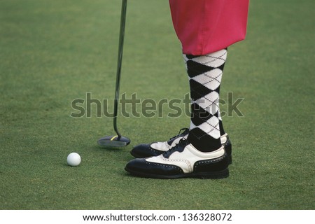 Close-up of the legs of a golfer Royalty-Free Stock Photo #136328072