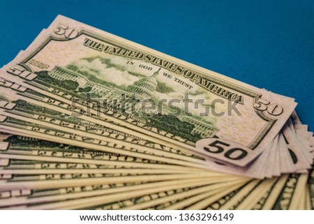 Large Fat Money Roll Isolated on a blue Background.