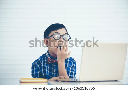 Little boy is yawning,  with a laptop, sleepy concept