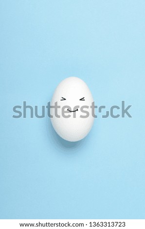 Kawaii faces on white eggs on a blue background. Cartoons, decoration food for children. Top view, flat lay.