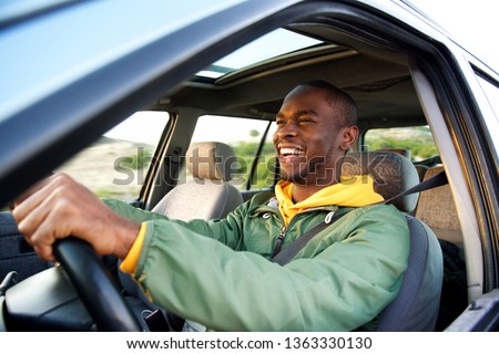 Side portrait of happy african american man driving car Royalty-Free Stock Photo #1363330130
