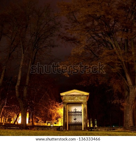 Small chapel in front of graveyard in the windy night.