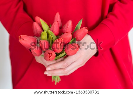 the girl hold the red tulips in the hand for happy mothers day or teachers day.