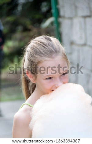Litle girl eat cotton candy, sweet and dirty