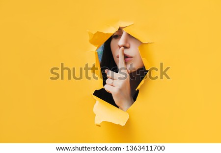 A young girl closes her lips with her index finger,making it clear to the viewer that you need to observe silence,keep a secret and not say too much. Censorship and harassment of freedom of speech.