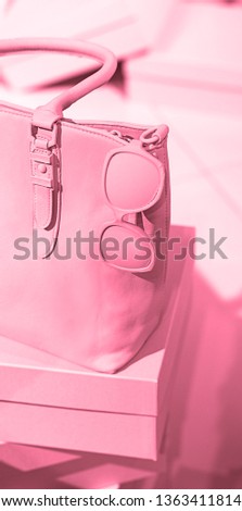 Concept of trendy female accessories bag, sunglasses, shoes on empty boxes and pastel pink background. Elegance fashion outfit. Minimal style. Selective focus, duotone effect. Copy space for text.