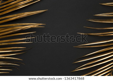Golden painted date palm leaves creative layout closeup border on dark black background isolated. Empty space, room for text. Minimalist style luxury wedding banner, invitation card template.