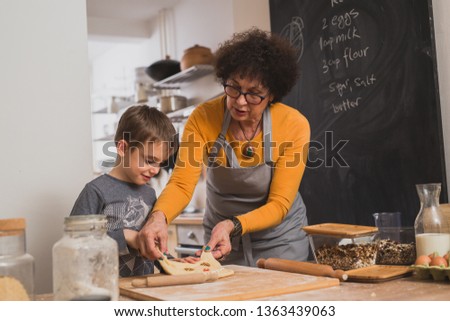 little boy helping his grandmother in kitchen