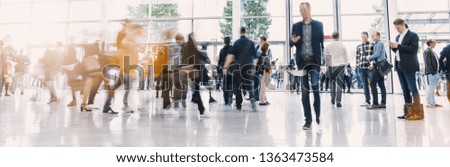 Crowd of anonymous people walking on a business center